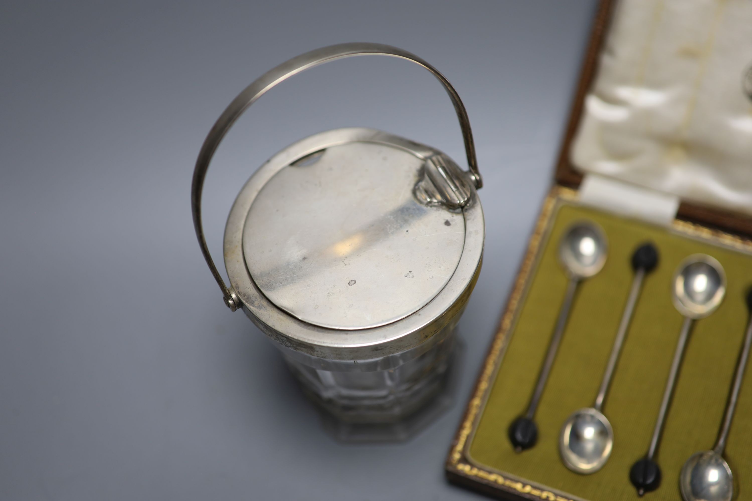 A cased set of six silver bean end coffee spoons and a George V silver mounted glass patent action sugar vase, (chipped foot).